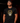 Adult baseball athlete wearing the black and gold 2023 San Diego Day of the Dead Cutternation tee in a dark batting facility