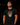 Adult baseball athlete wearing the black and gold 2023 San Diego Day of the Dead Cutternation tee in a dark batting facility