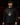 Adult baseball athlete wearing the red black and white Day of the Dead Cutternation Champion hoodie in a dark batting facility