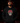 Adult baseball athlete wearing the red gold black and white Day of the Dead Cutternation Champion hoodie in a dark batting facility