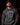 Adult baseball athlete wearing the charcoal 2024 Day of the Dead Cutternation hoodie in a dark batting facility