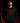 Adult baseball athlete wearing the black Alabama Color Cutternation Champion hoodie with crimson pitcher logo in a dark batting facility