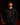 Adult baseball athlete wearing the black Alabama Color Cutternation Champion hoodie with crimson pitcher logo in a dark batting facility