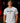 Adult baseball athlete wearing the white Been There Cutternation tri-blend tee in a dark batting facility