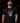 Adult baseball athlete wearing the black monochrome Day of the Dead Cutternation tri-blend tee in a dark batting facility