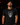 Adult baseball athlete wearing the black monochrome Day of the Dead Cutternation tri-blend tee in a dark batting facility