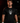 Adult baseball athlete wearing the black Skull Hat Cutternation performance tee in a dark batting facility