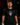 Adult baseball athlete wearing the black Skull Hat Cutternation performance tee in a dark batting facility
