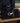 Three black Cutternation 30 x 60 training towels displayed together on a baseball dugout bench