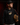 Teen baseball player wearing black Cutternation Punching Tickets youth hoodie in a dark training facility