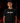 Youth baseball player wearing a black Cutternation Qué Raro T-shirt in an indoor batting cage