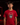 Youth baseball player wearing a red Cutternation Red and Yellow Day of the Dead T-shirt in an indoor batting cage