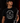 Teen baseball player wearing black Cutternation Strikeout Season youth T-shirt in a dark training facility
