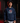 Youth baseball player wearing a navy Cutternation Vice palm graphic hoodie in an indoor batting cage
