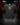 Youth Baseball T-Shirt — Gingerbread Cookie — Cutternation 4:5 product hero in a black and red indoor baseball training facility